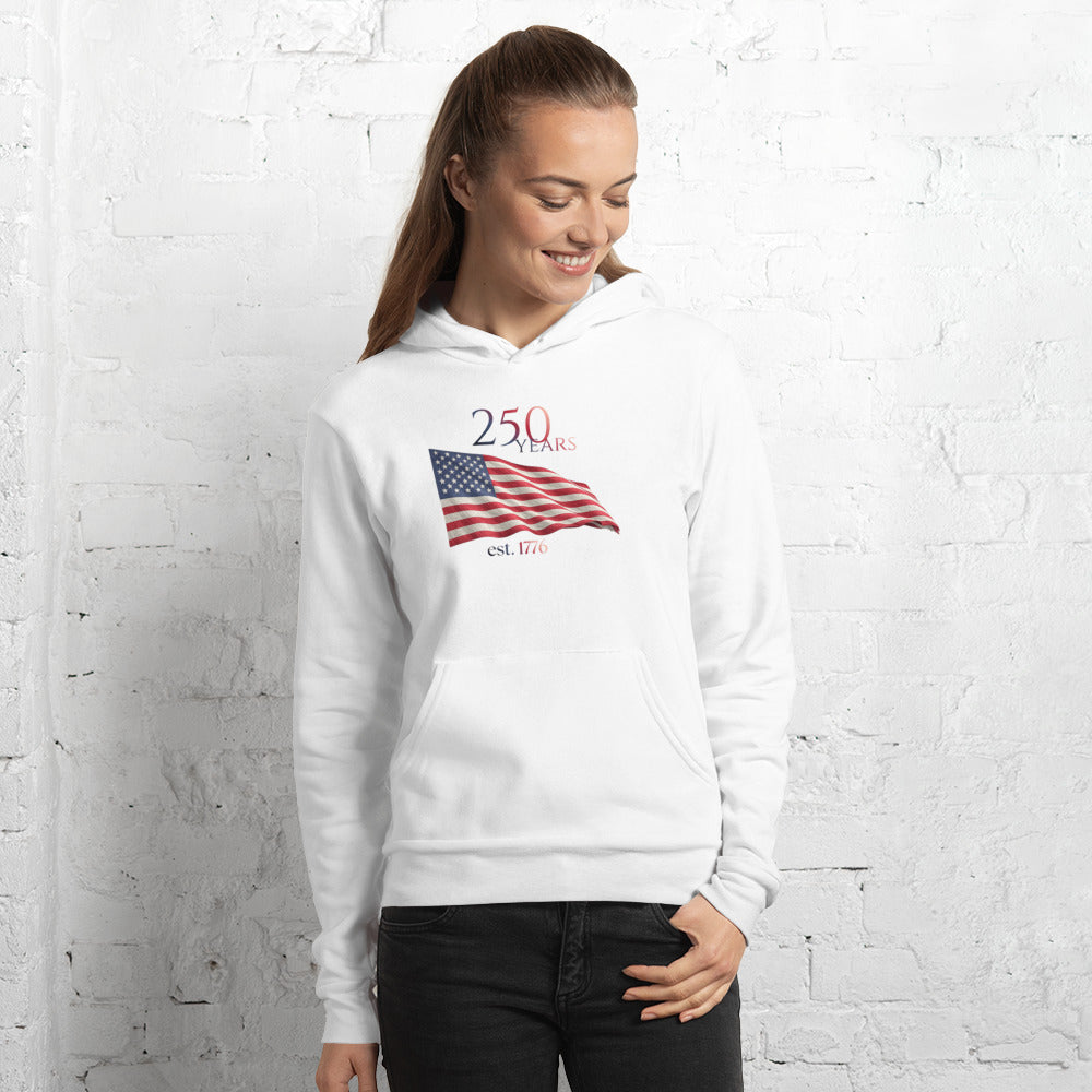 Woman wearing America 250th anniversary white hoodie American flag graphic Est 1776 unisex fit Bella Canvas